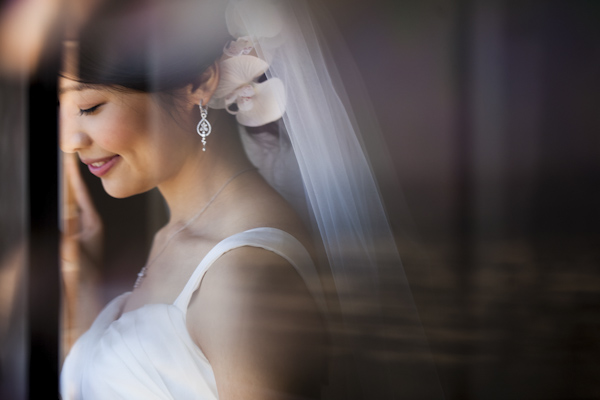 smiling bride looking out window - wedding photo by top Orange County, California wedding photographers D. Park Photography